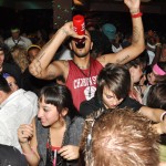 Ron Hudson, 19, sophomore of Detroit, takes a swig from his water bottle as multitudes of people dance around him at the Late Night at The Pit 80s Night Thursday. &mdash; Photo by Vera Ulitina