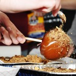 Crushed candy coats a caramel-covered apple at Thursday’s event "Apple Bobbing," sponsored by Chi Alpha, in the Student Center. — Photo by Vera Ulitina