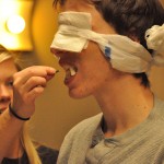 Liz Rice, sophomore of Ravenna, feeds an apple and peanut butter to James Safarik, sophomore of Hyannis, during the “Going Nuts for Peanut Butter” RLA event on Monday. Blindfolded students tasted different foods with peanut butter topping. — Photo by Kinley Q. Nichols