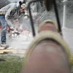 Construction workers use a saw to cut through a cement block during construction Tuesday. — Photo by Ashley Swanson