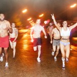 A group of students run on Main Street in front of Memorial Hall during the Nearly Naked Mile run Thursday. - Photo by Ashley Swanson
