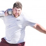 Cody Hunt, senior of Lingle, Wyo., nestles a steel sphere in his shoulder in preparation to hurtle it across the practice fields on the southeast corner of campus Tuesday. Hunt is a criminal justice major. — Photo by T.J. Thomson