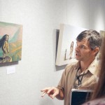 Jason Godeke of Bloomsburg, Penn., talks about the process he goes through when creating a painting with Nicole Jeffries, 19, sophomore of Wheatland, Wyo., during the Art Reception Monday in Memorial Hall. — Photo by Ashley Swanson