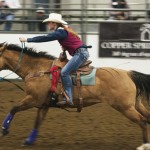 Rebeka Bodine, sophomore of Bennett, Colo., races out into the barrel event in a rodeo last season. — Photo by Kinley Q. Nichols