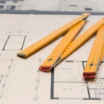 A pencil and ruler lie on a set of architectural renderings. –Photo by Jean Scheijen